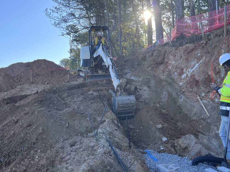 Mini excavator digging the base for a retaining wall