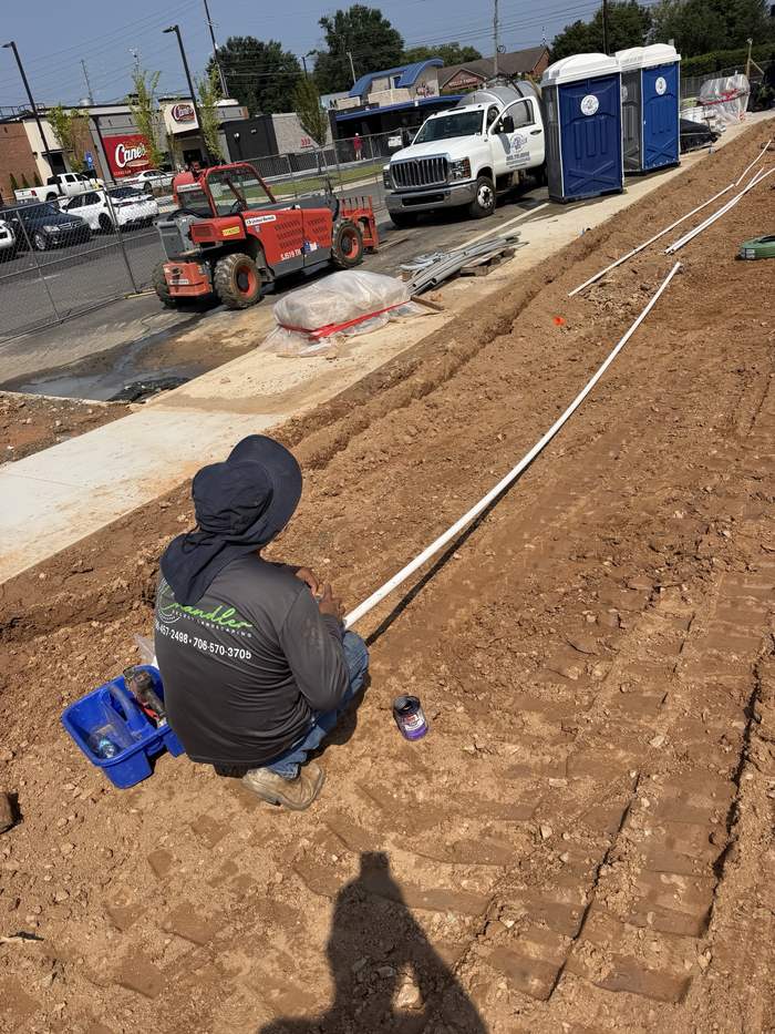 Crew gluing irrigation pipe on a commercial site in Kennesaw