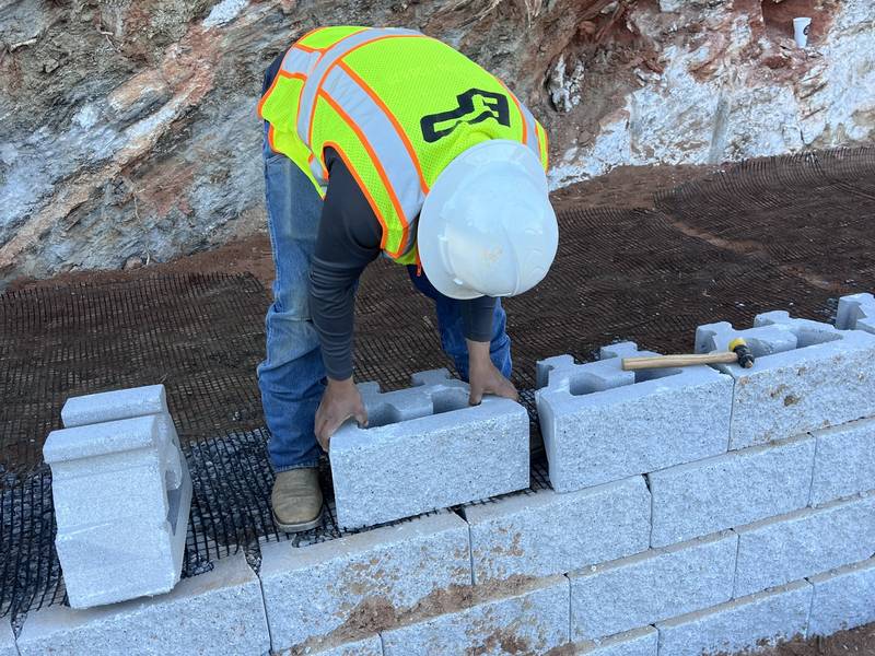 Crew member setting block on geogrid