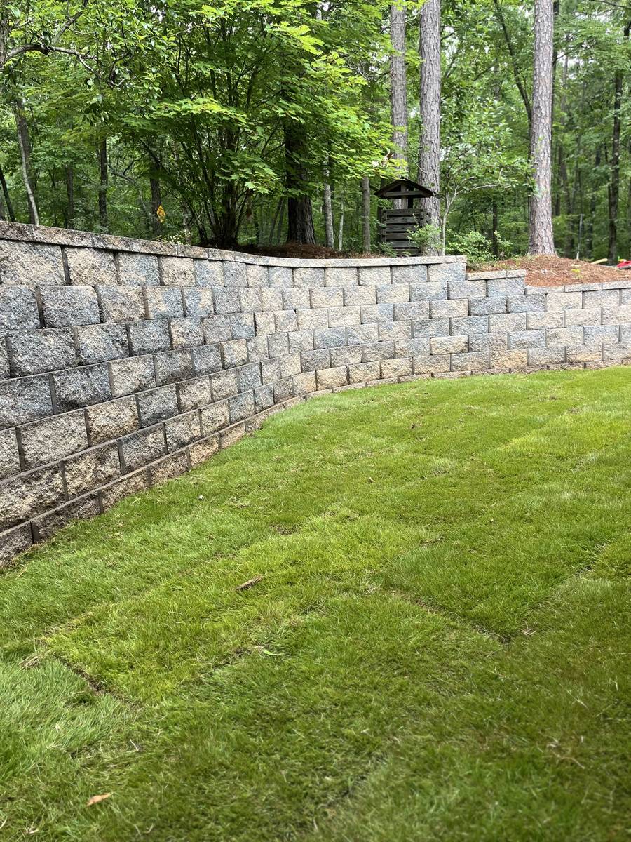 Curved block retaining wall with new sod lawn