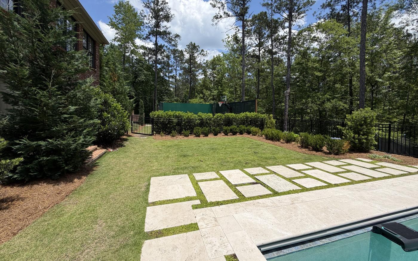 Travertine pool deck with lawn and boxwood beds